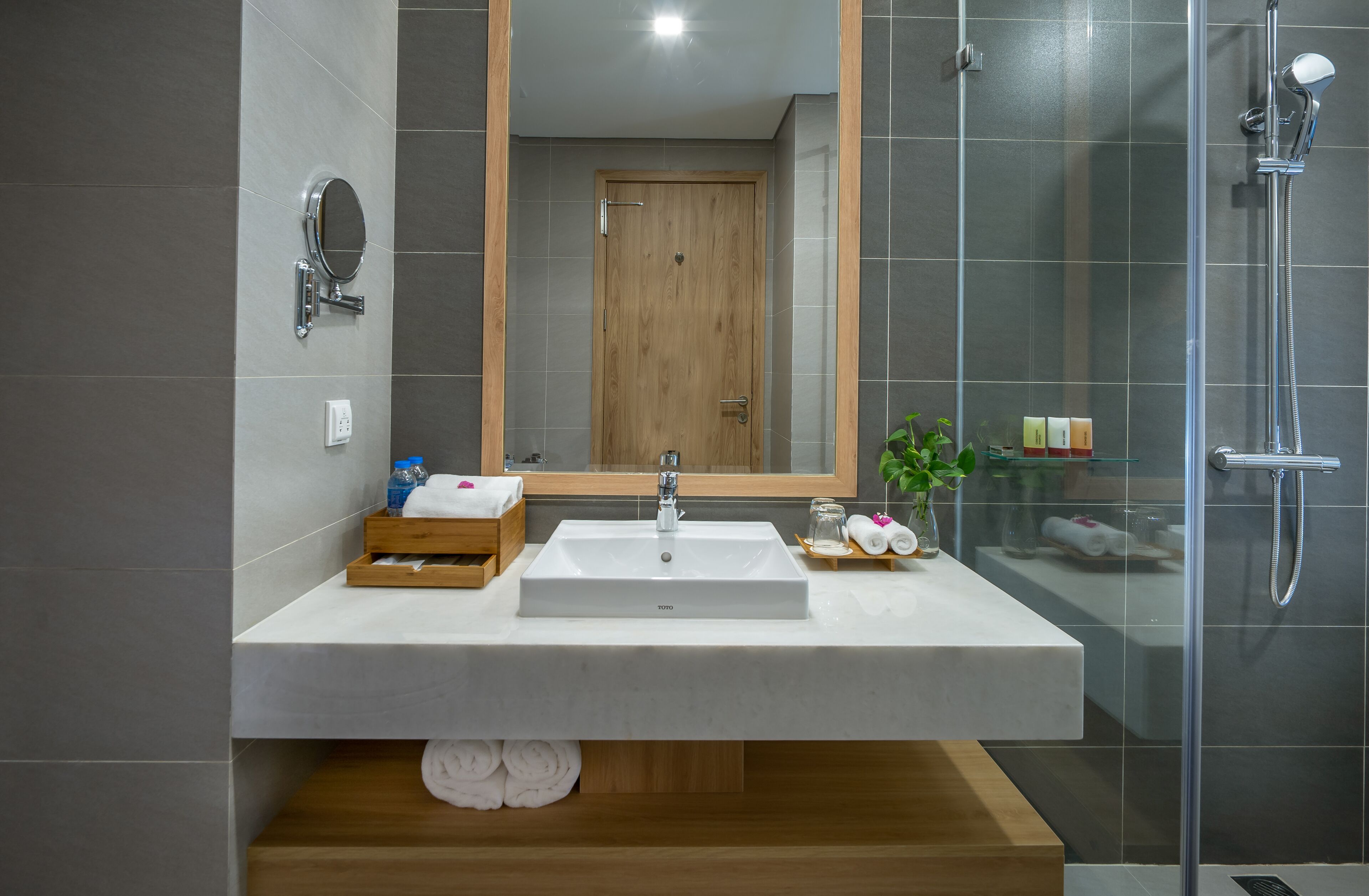 Un bagno moderno con un ampio specchio, un lavandino e una doccia.