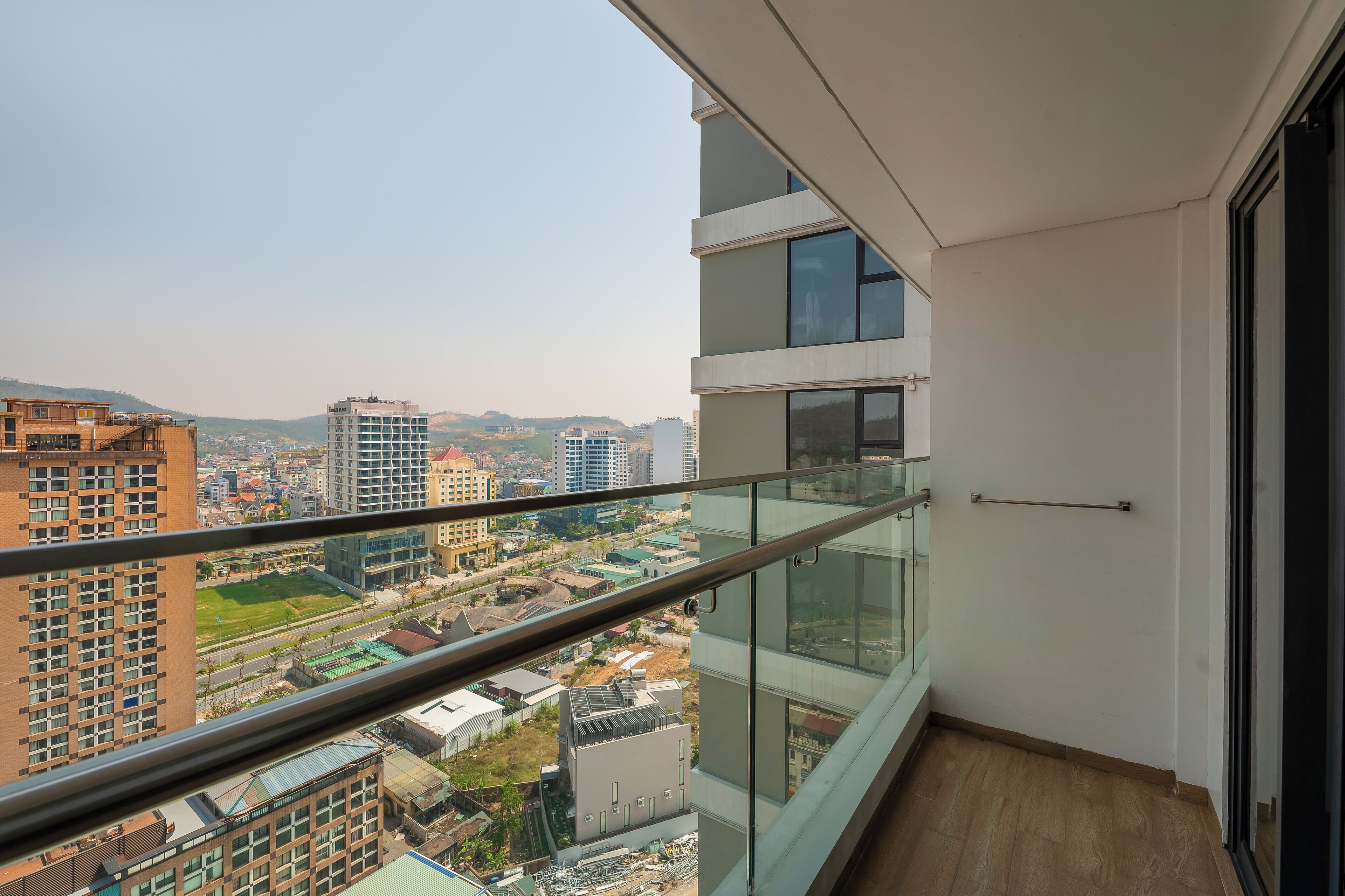 A high-rise apartment with a balcony, offering a city view.