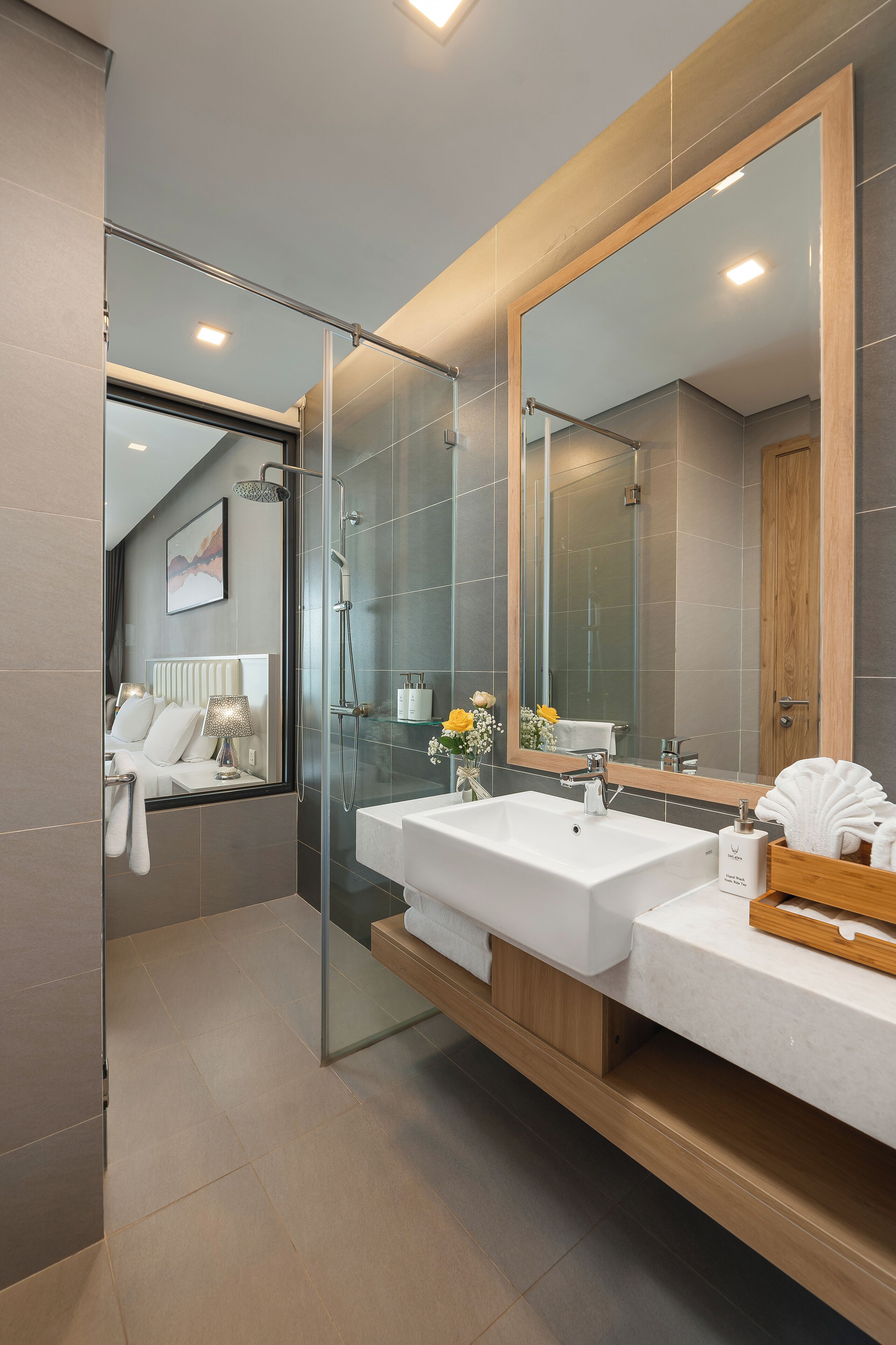 A modern bathroom with a glass-enclosed shower, a large mirror, and a dual sink vanity.