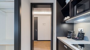 Una cocina moderna equipada con microondas, cafetera y un refrigerador pequeño.