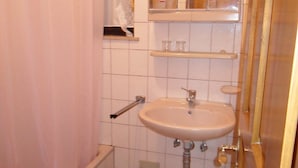 A bathroom with a bathtub, a sink, a mirror, and a shower curtain. - Guest House Lidus (Gradac)
