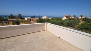 Eine Dachterrasse mit freiem Blick auf das Meer und die umliegenden Gebäude.