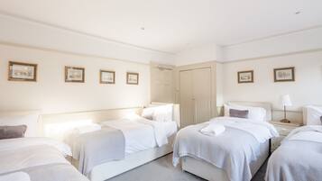 Une chambre d’hôtel avec deux lits simples, une table de chevet avec une lampe et une armoire.