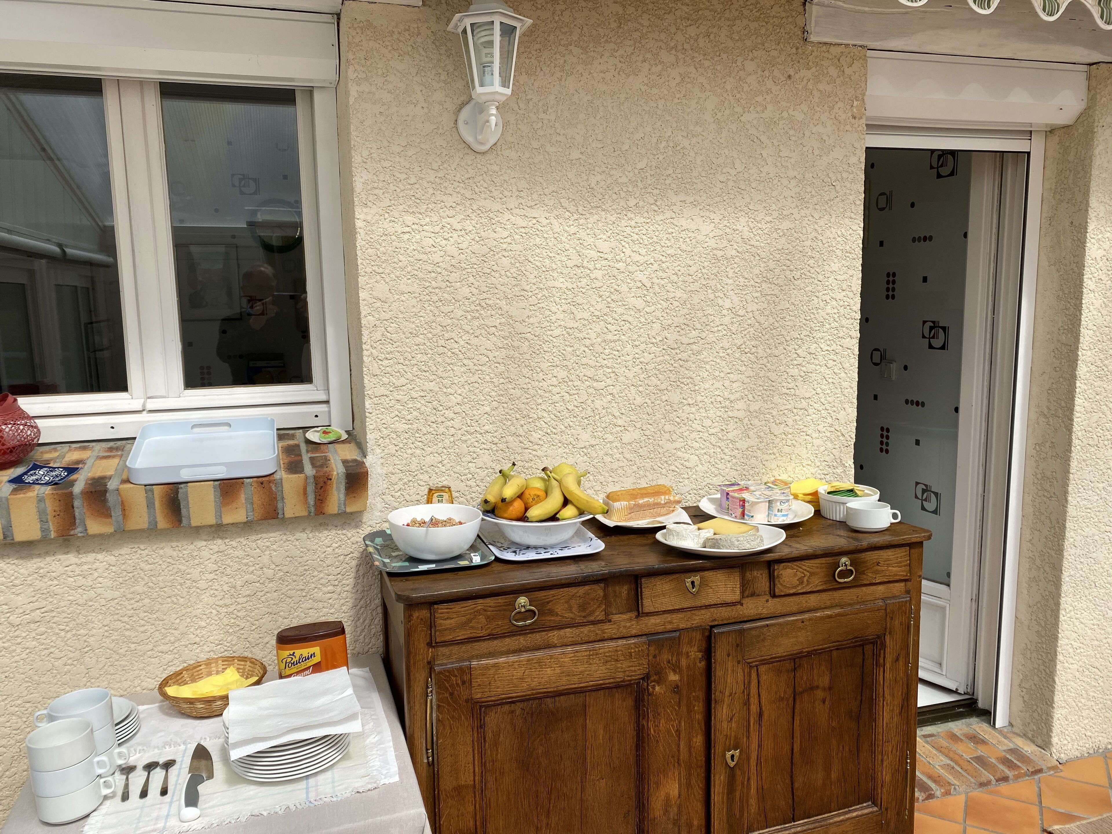 Un coin cuisine avec un meuble en bois, une fenêtre donnant sur un beau paysage et divers aliments pour le petit-déjeuner disposés sur le comptoir.