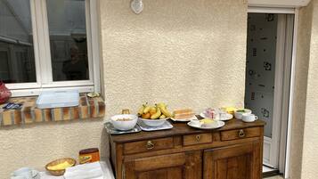 Un coin cuisine avec un meuble en bois, une fenêtre donnant sur un beau paysage et divers aliments pour le petit-déjeuner disposés sur le comptoir.