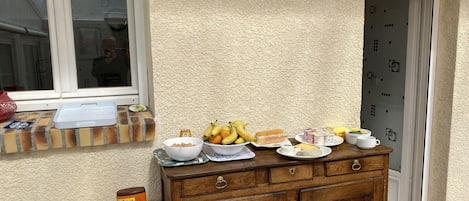 Una cocina con un armario de madera, una ventana con vistas y diversos productos para el desayuno sobre la encimera.