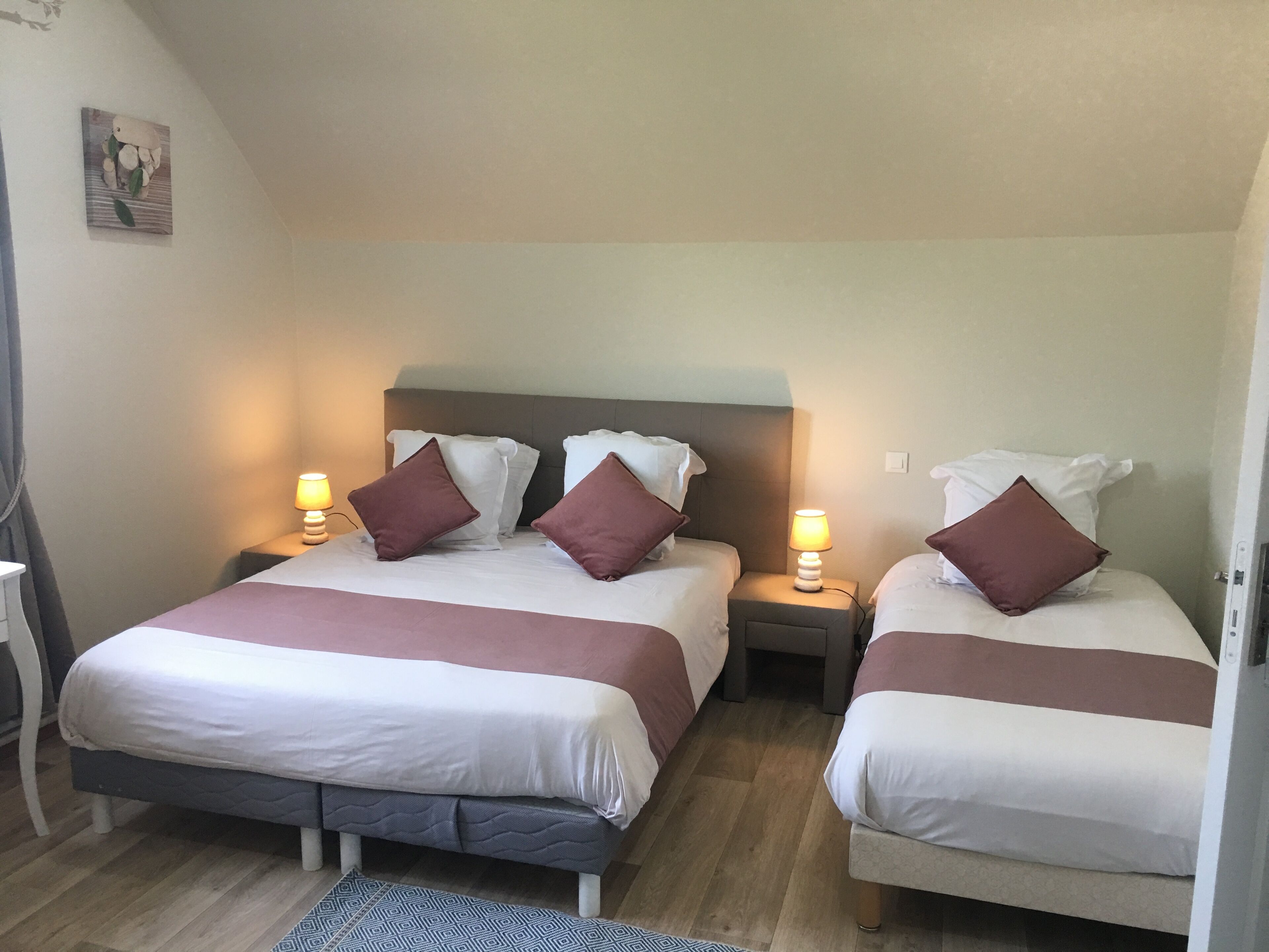 Ett hotellrum med två sängar, var och en med en kudde och en sänglampa.