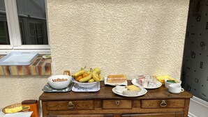 Ein Frühstückstisch mit verschiedenen Speisen vor einer strukturierten Wand.