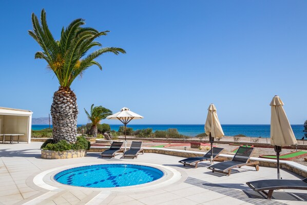 Piscine extérieure, parasols de plage, chaises longues