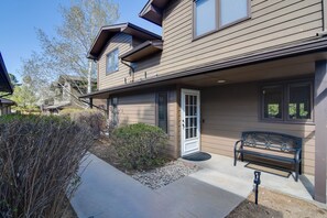 A two-story house with a front porch, a bench, and a small garden area. - Fireplace & Mtn Views: Estes Park Home w/ Deck! (Estes Park)