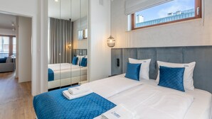 Ett hotellrum med en stor säng, en spegel, ett fönster med utsikt och en separat sittgrupp.