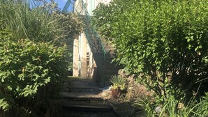 Una escalera de piedra que conduce a un edificio con fachada de piedra y una puerta verde.