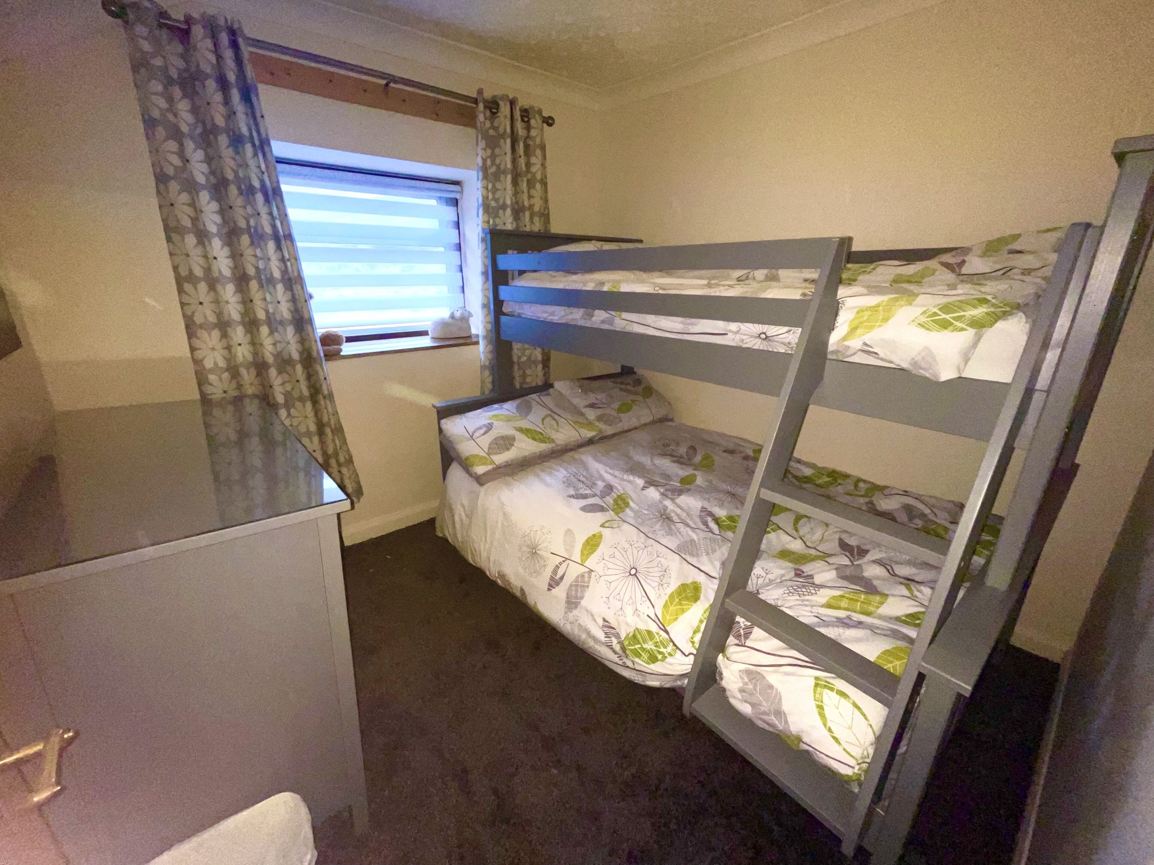 Dormitorio con literas, ventana y cortinas.