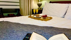 A hotel room with a bed, a tray with breakfast, a remote control, and an open book. - Sleeps 8 Snowdonia North Wales Nr Zip World (Blaenau Ffestiniog)