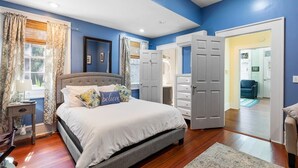 A bedroom with a large bed, a nightstand, a dresser, and a walk-in closet. - ♥Home Too♥ in downtown Charleston, by MUSC (Charleston)