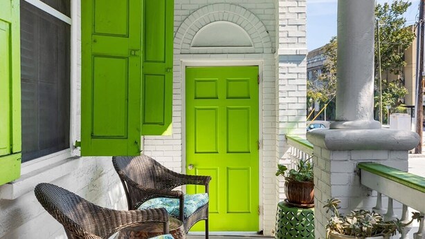 A bright green door with a white brick wall and a white porch with wicker chairs. - ♥Home Too♥ in downtown Charleston, by MUSC (Charleston)