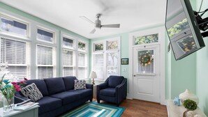 A living room with a dark blue sofa, a patterned rug, and a ceiling fan. - ♥Home Too♥ in downtown Charleston, by MUSC (Charleston)