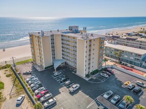 Un hôtel à plusieurs étages doté d’un parking et offrant une vue sur la plage.