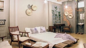 A modern bedroom with a large bed, wooden furniture, a brick wall, and a ceiling light fixture. - Nha Saigon (Ho Chi Minh City)