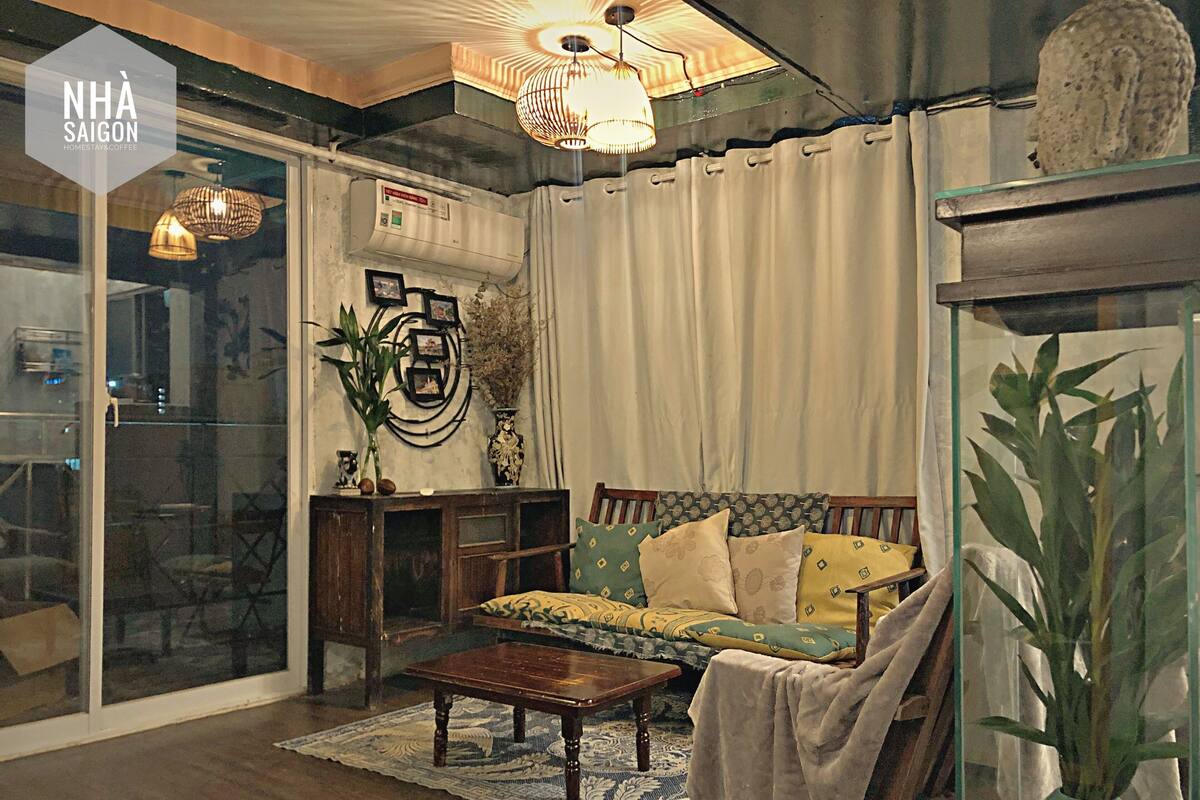 Uma sala de estar acolhedora com um sofá, uma mesa de centro e um painel de vidro.