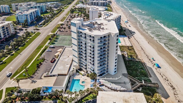 A high-rise hotel with multiple floors, a swimming pool, and a beach view. - Luxury 2/2 Condo with the Best Ocean View! (New Smyrna Beach)