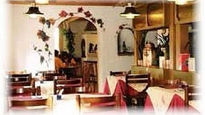 A restaurant interior with booths, a central archway, and hanging light fixtures. - Hotel Post Vista (Zweisimmen)