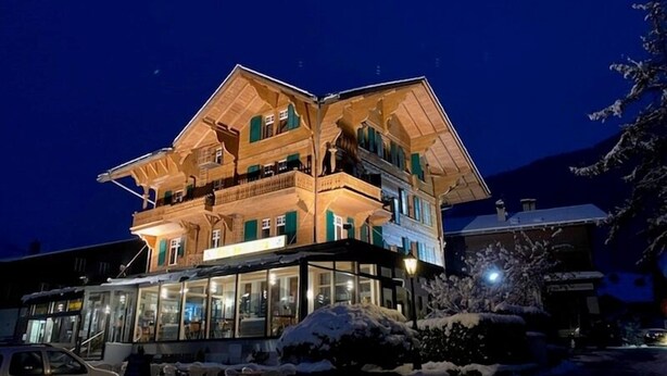 A multi-story building with balconies, large windows, and a snow-covered ground. - Hotel Post Vista (Zweisimmen)