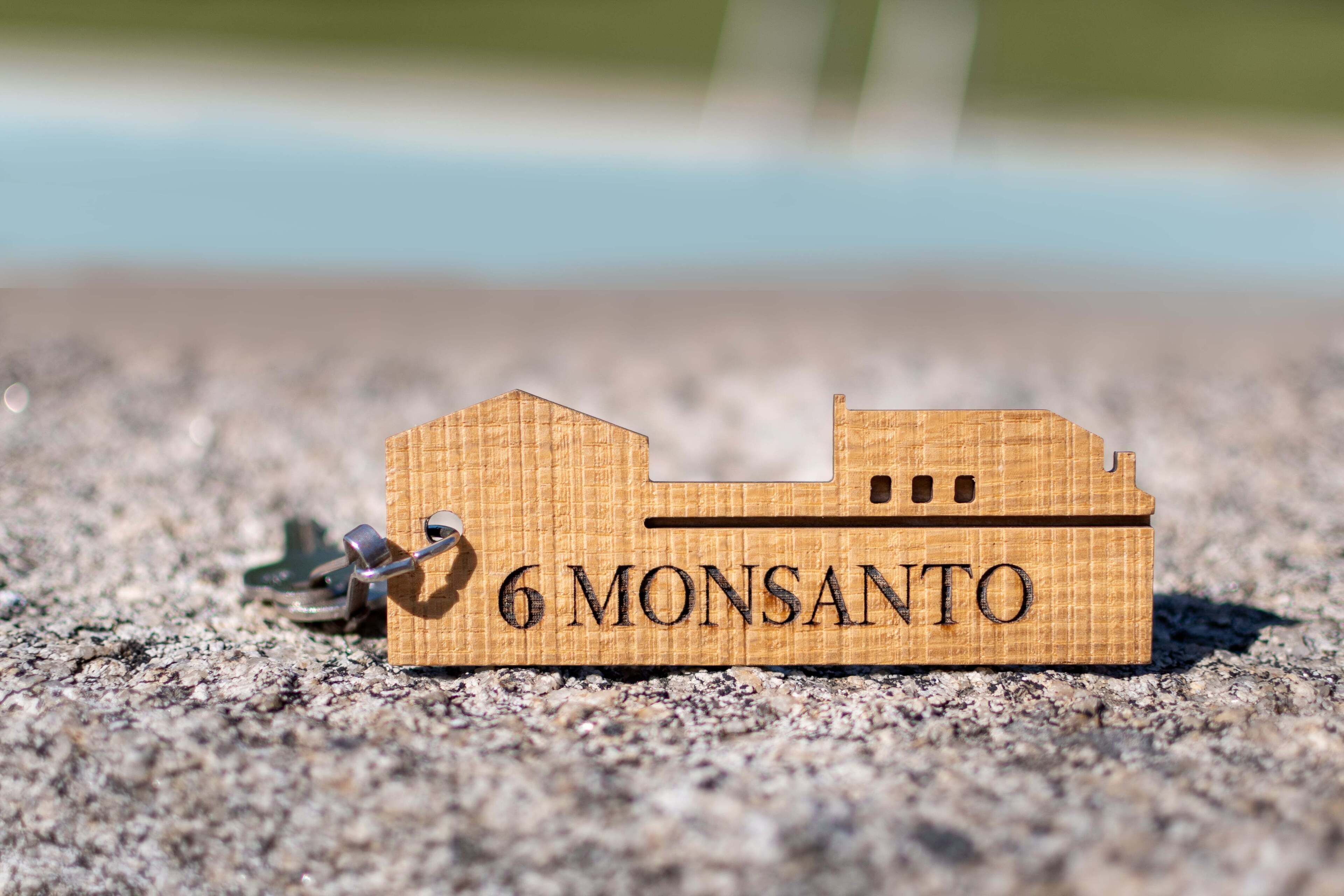 Un llavero de madera con forma de barco y la inscripción '6 MONSANTO'.