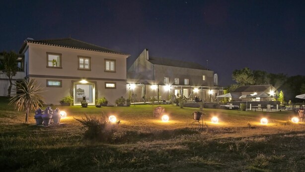 Un edificio grande de dos pisos con un patio y luces exteriores.