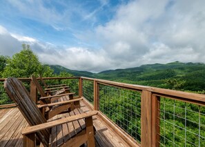 A wooden deck with chairs overlooking a lush green landscape. - The Brindle Barn | Pet Friendly, Fenced Yard & Stunning Views (Black Mountain)