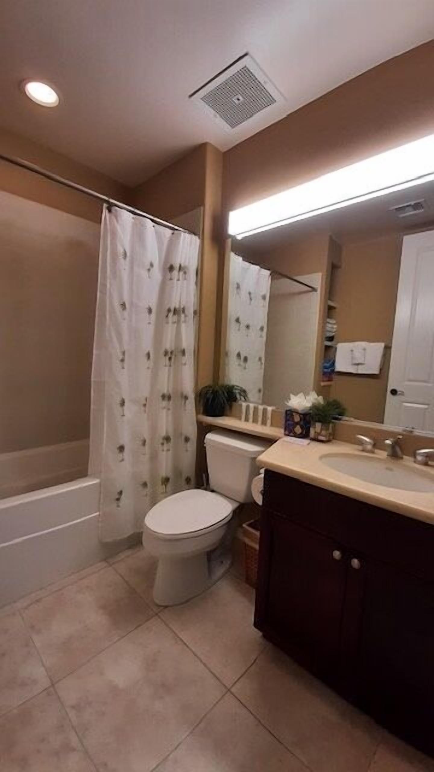 A bathroom with a toilet, sink, and shower area.
