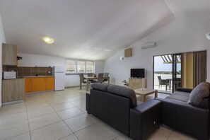 A compact living space with a kitchenette, a dining area, a sofa, and a TV. - Comfort apartments with pool in Medulin (Medulin)