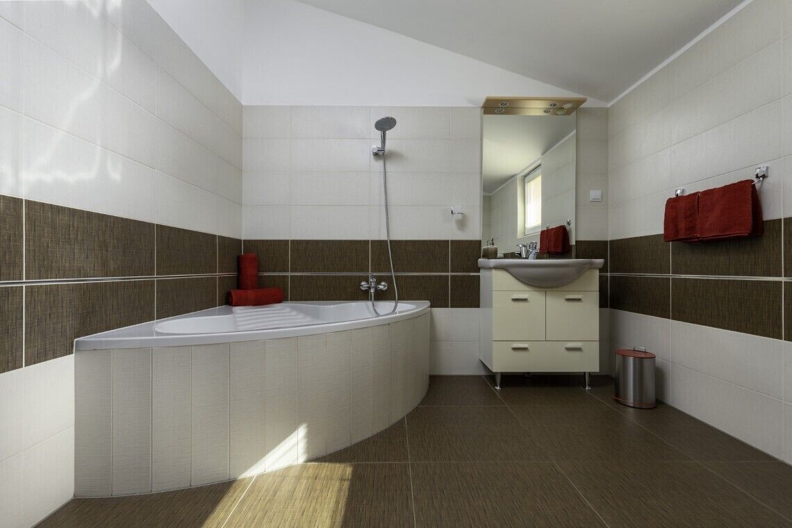 Ein modernes Badezimmer mit freistehender Badewanne, einem Waschtisch mit Spiegel und einer Duschbrause.