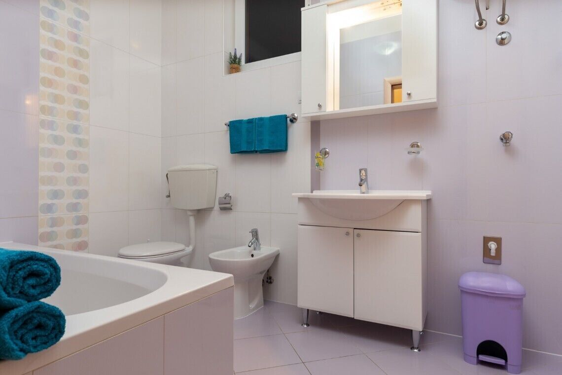 Ein Badezimmer mit Badewanne, Toilette, Bidet und Waschtisch mit Spiegel.