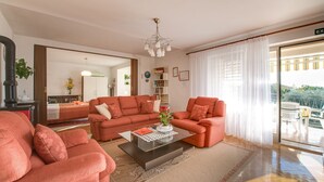 Ein Wohnzimmer mit einer Sofagarnitur, einem Couchtisch und einer Deckenleuchte.