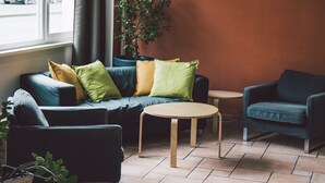 A modern living room with a sofa set, a round coffee table, and a small side table. - Happy Hotel Berlin (Berlin)
