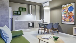 Una sala de estar moderna con un sofá verde, una mesa de centro de madera y un comedor con sillas y una mesa.
