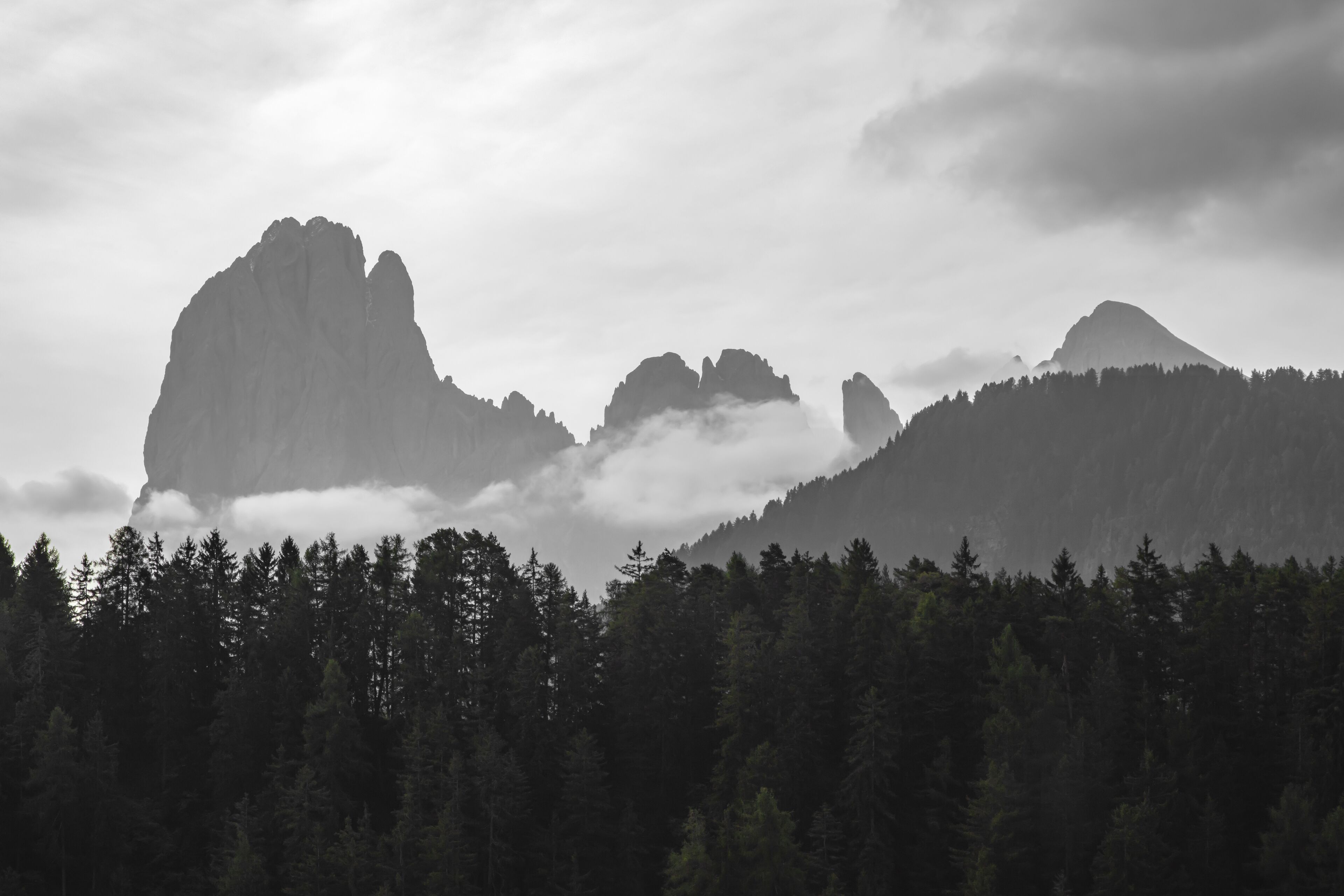 Un paysage montagneux boisé, caractérisé par des formations rocheuses imposantes et une végétation arborée dense.