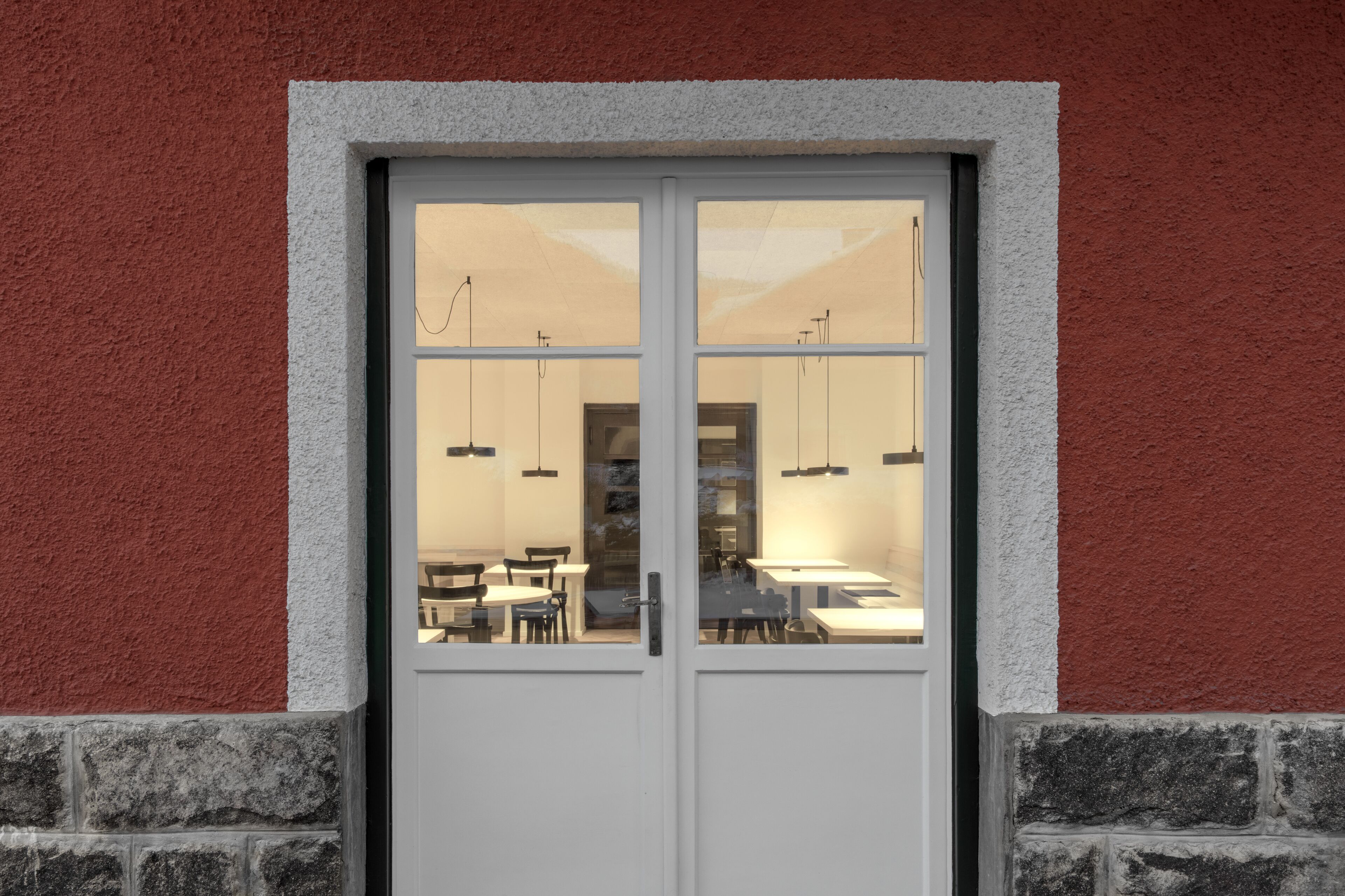 Puertas dobles que dan a una habitación con mesas y sillas.