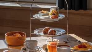 Un bufé de desayuno con una variedad de pasteles, frutas y bebidas sobre una mesa de madera.