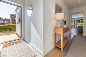 Enter a welcoming space with a large mirror, console table, and potted plant, leading to a seamless transition to the outdoors.