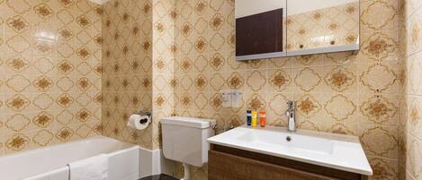 A bathroom with a toilet, sink, and bathtub.