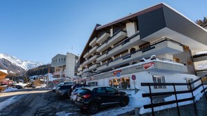 Un hotel de varios pisos con un área de estacionamiento al frente.