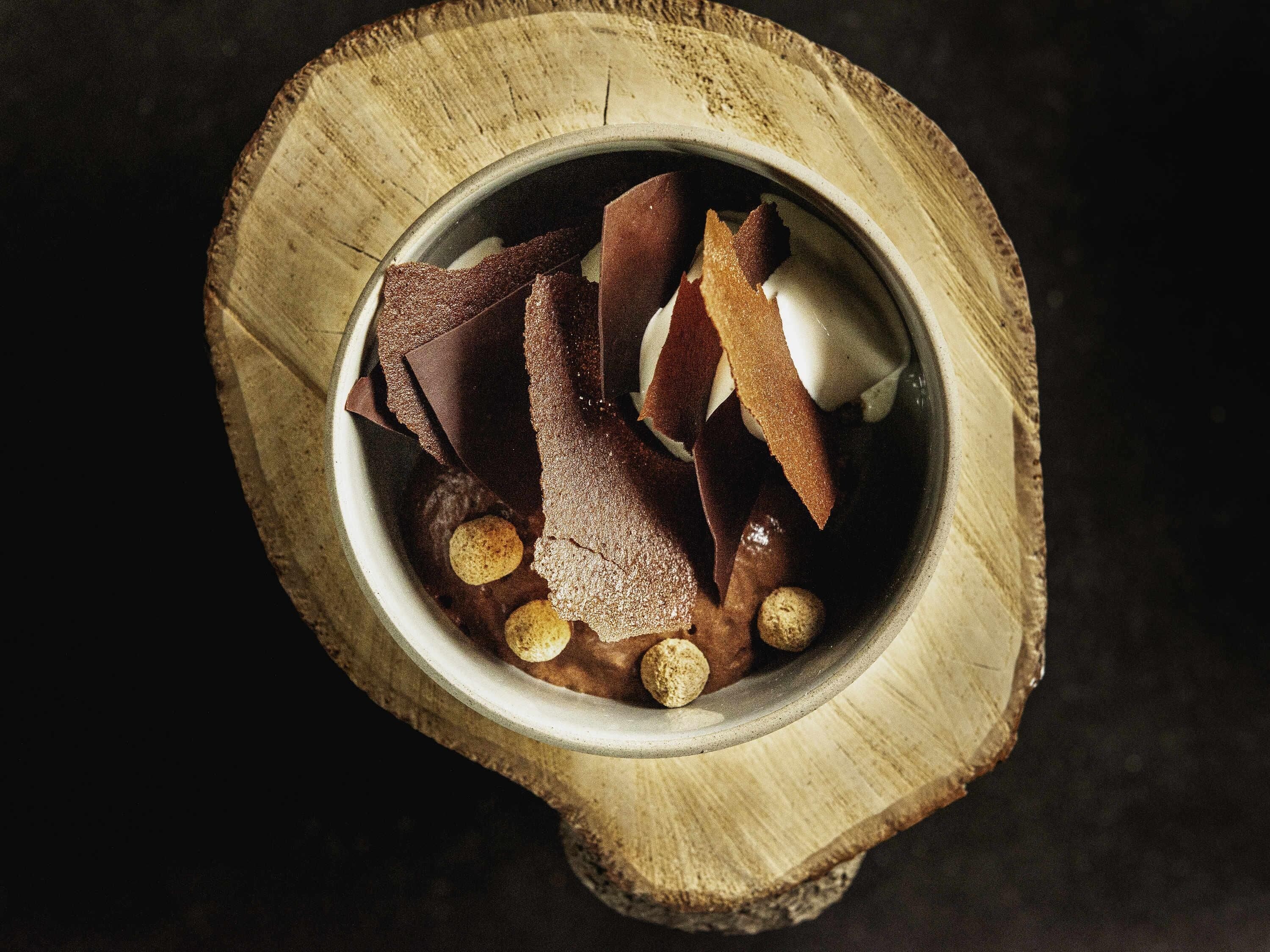 A dessert in a bowl on a wooden surface.