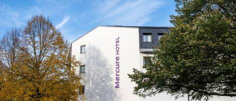 A modern hotel building with a prominent "Mercure Hotel" sign on the facade.