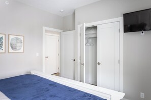 A bedroom with a bed, a wardrobe, and a TV.