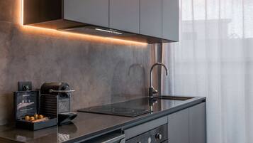 Een moderne keuken met een ingebouwde oven, een spoelbak en een koffieapparaat.