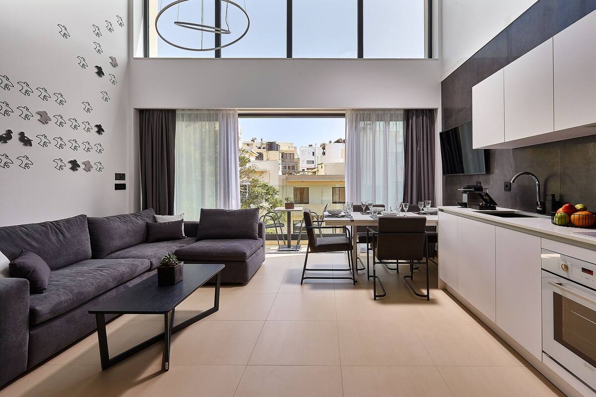 A modern apartment with a living area, dining space, and kitchen.