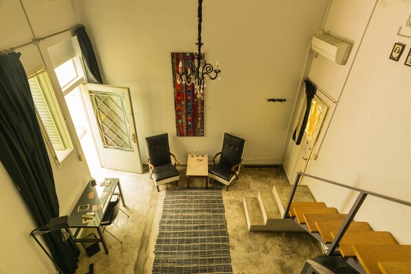 A room with a desk, two chairs, a rug, a chandelier, and a staircase. - Palermo Viejo Bed & Breakfast (Buenos Aires)