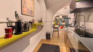 A modern kitchen with a yellow shelf, a coffee maker, and a kettle.